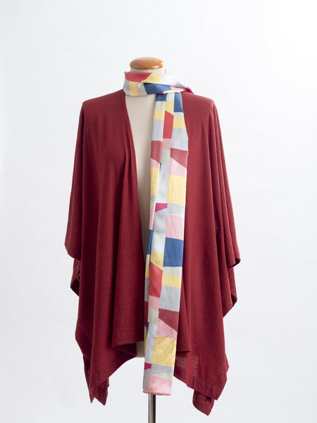 Mod Colour Block scarf, a geometric layering of muted bright hues, this scarf goes with almost anything! Soft blocks of blue, blush, cerise, garnet rust, sage, yellow, grey and pale blue melded together to take versatility to a whole new level. Self-lined in a tubular shape so it stays put hanging, or ties easily, never loosing shape and looking great no matter how you wear it.  100% silk satin Luxury, paired here with a garnet rust Muse wrap.