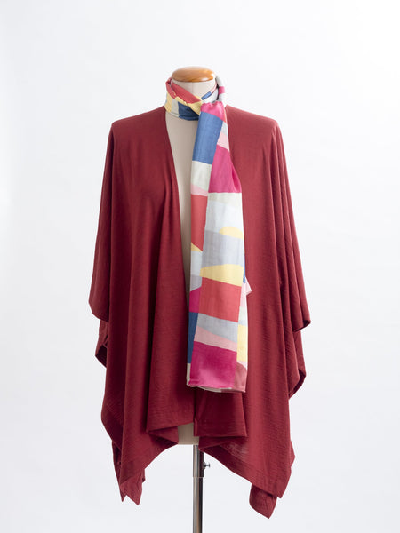 Mod Colour Block scarf, a geometric layering of muted bright hues, this scarf goes with almost anything! Soft blocks of blue, blush, cerise, garnet rust, sage, yellow, grey and pale blue melded together to take versatility to a whole new level. Self-lined in a tubular shape so it stays put hanging, or ties easily, never loosing shape and looking great no matter how you wear it.  100% silk satin Luxury, paired here with a garnet rust Muse wrap.