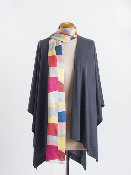 Mod Colour Block scarf, a geometric layering of muted bright hues, this scarf goes with almost anything! Soft blocks of blue, blush, cerise, garnet rust, sage, yellow, grey and pale blue melded together to take versatility to a whole new level. Self-lined in a tubular shape so it stays put hanging, or ties easily, never loosing shape and looking great no matter how you wear it.  100% silk satin Luxury, paired here with a charcoal muse wrap.